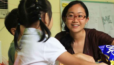 Pamela Soo shares a snack with her students during Bible class at the Moulmein Road Church of Christ in Singapore. – PHOTO BY ERIK TRYGGESTAD