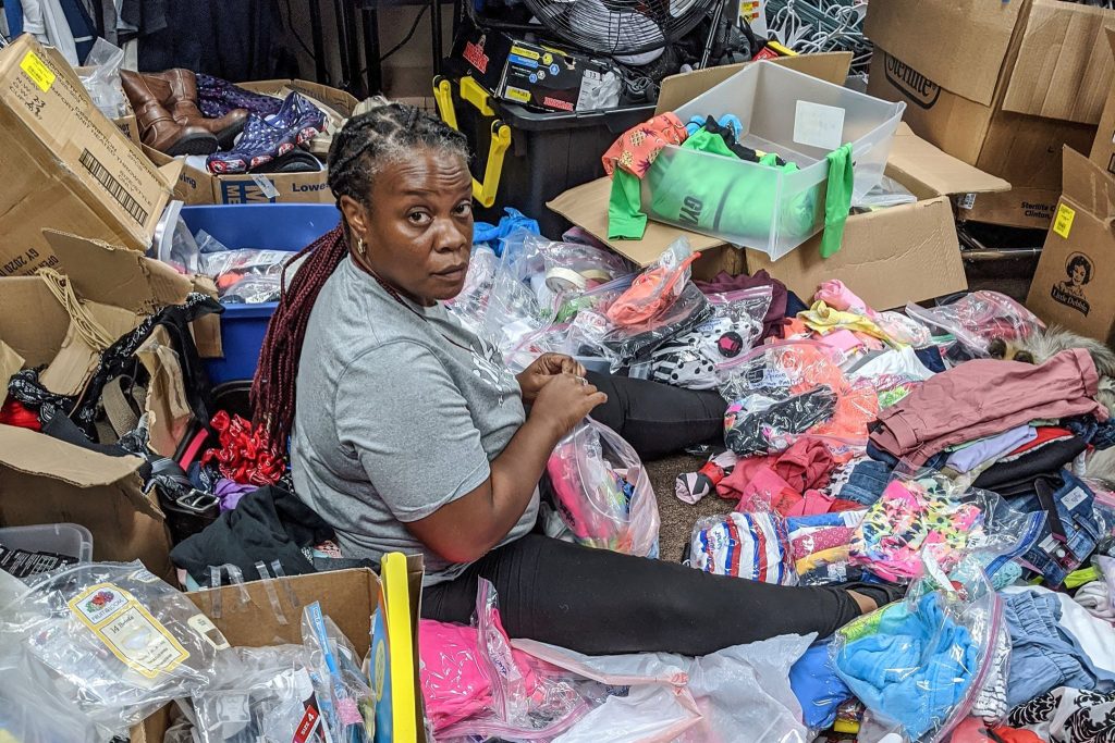 Rose Williams sorts piles of donated items for the Renew Common Goods ministry.