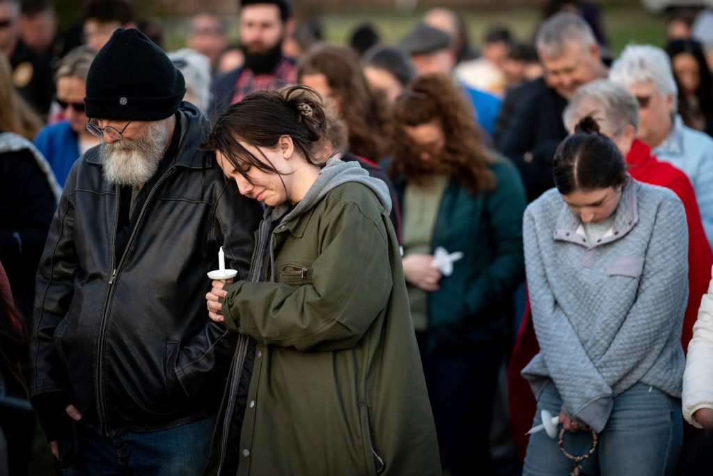 People pray for the victims of The Covenant School shooting during a community vigil in Mt. Juliet, Tenn.