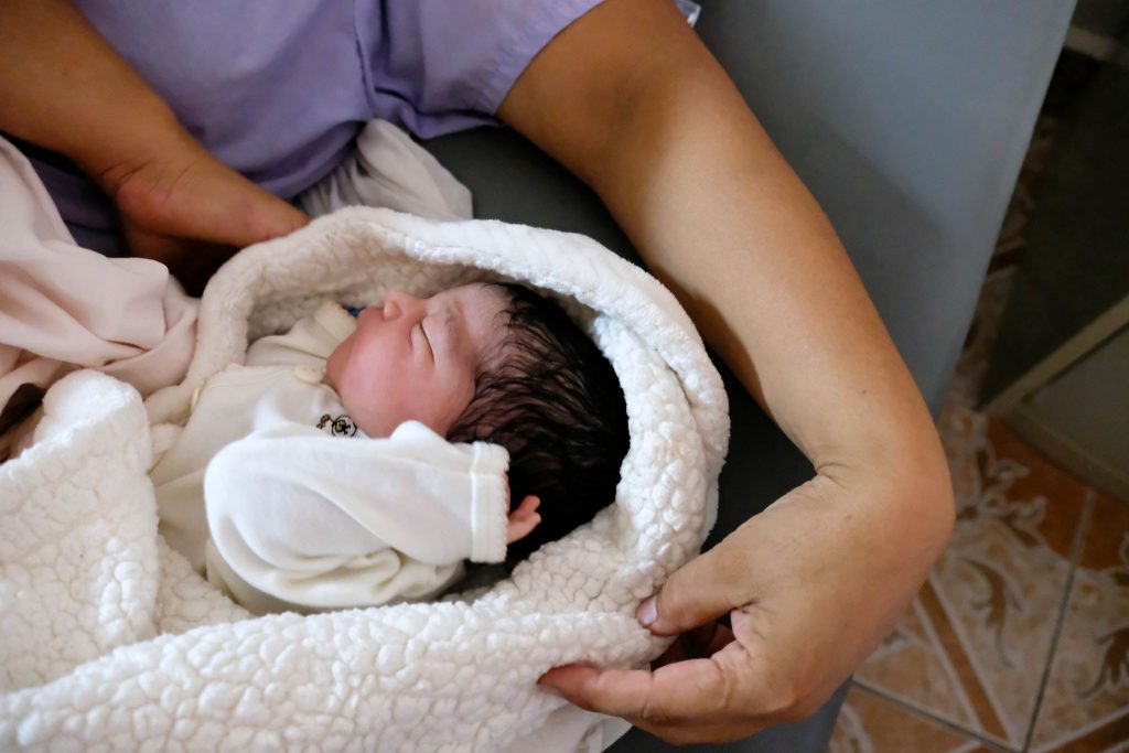 A baby boy born hours before sleeps next to his mother at the Culmi clinic.