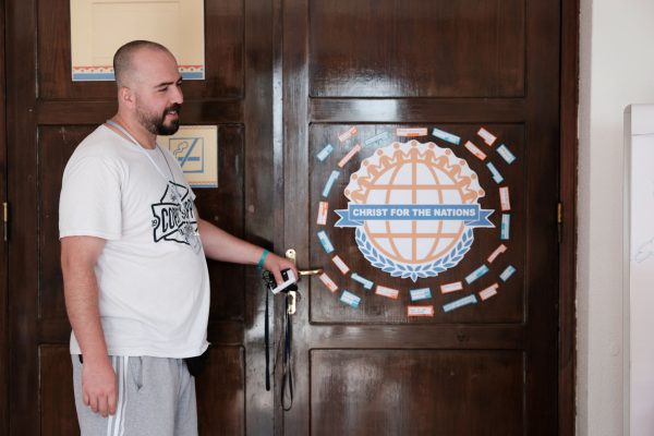 Ibrahim Fatahi, an Iranian Christian, opens a door with the words, “Christ for the nations,” translated into 29 languages.