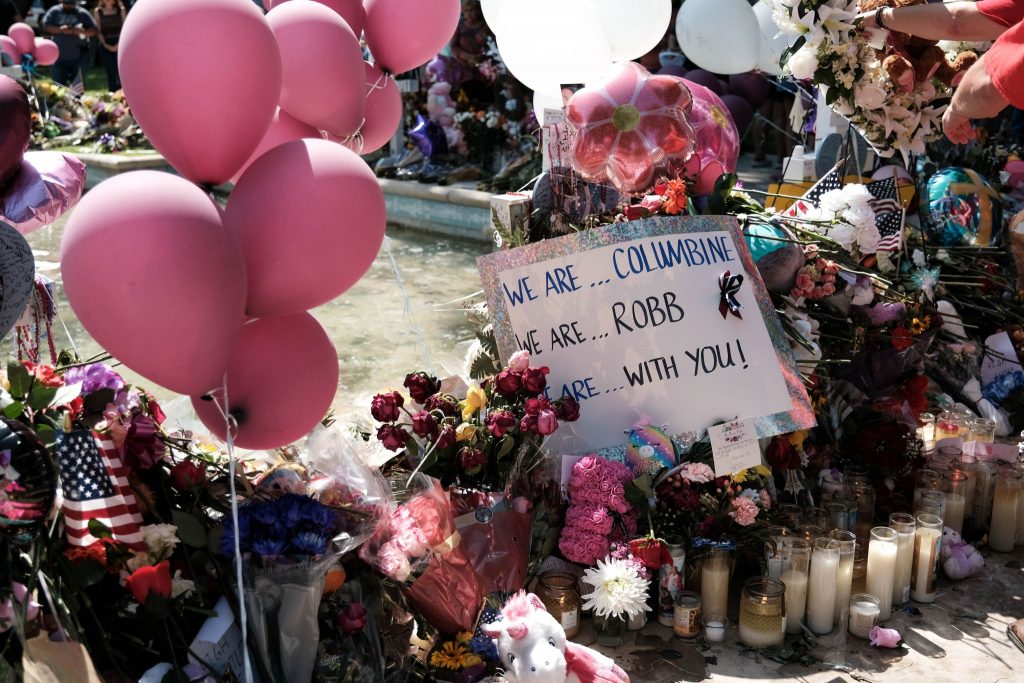 A sign left by Columbine shooting survivors at the courthouse memorial shows solidarity.