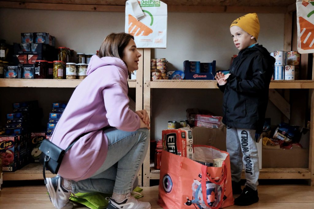 Yulian Parfenenko, 6, helps his mother, Alyona, with grocery shopping at the free resource center run by the Cluj-Napoca Church of Christ in Romania. The Parfenenko family fled Odessa, Ukraine, at the beginning of March.