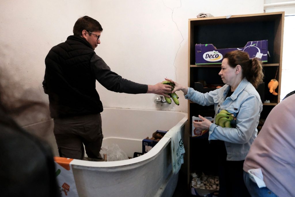 Ukrainian volunteers restock the produce section of the refugee resource center in the Cluj-Napoca Church of Christ.