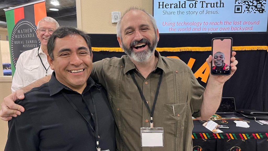 Javier Leon, director of the Avanza Líder ministry in Dallas, shares a laugh with Trey Henry, a minister for the Hillcrest Church of Christ in Arlington, Texas, and (via phone) a worker with Chivero Mission in Zimbabwe.