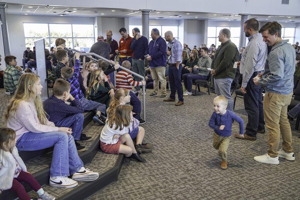 Children listen (mostly) as men who regularly lead the Heritage church's Kid's Message Time read Bible verses during the congregation's grand opening service.