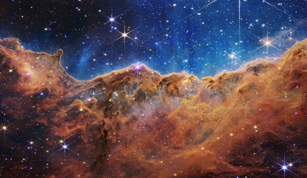 NASA’s new James Webb Space Telescope captures the edge of a nearby, young star-forming region in the Carina Nebula called NGC 3324, disclosing for the first time previously unseeable areas of star birth. The tallest “peaks” in the photo are about 7 light-years high. ACU graduate Scott Acton helped develop the telescope.