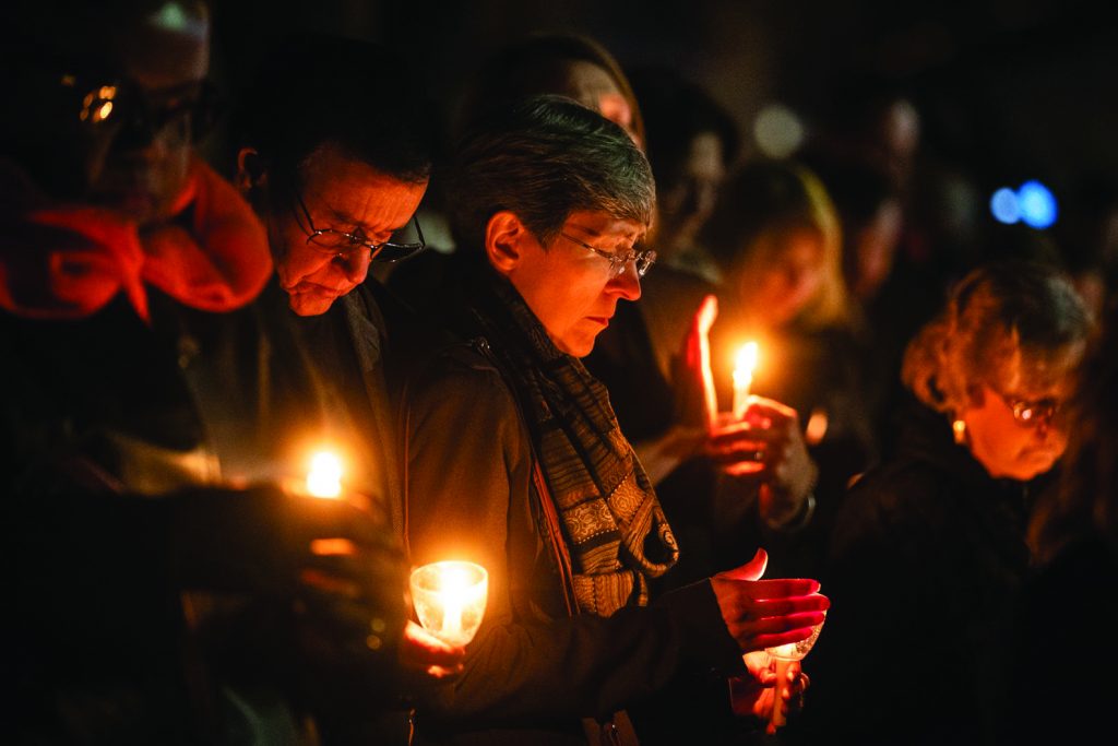 Community members light candles Monday night during a vigil outside the West Freeway Church of Christ building in White Settlement, Texas.