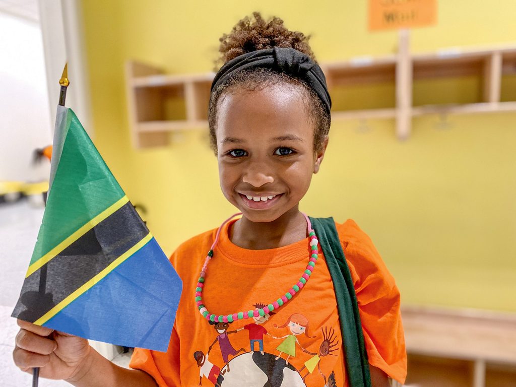 A camper holds a flag of Tanzania, whose embassy she visited.