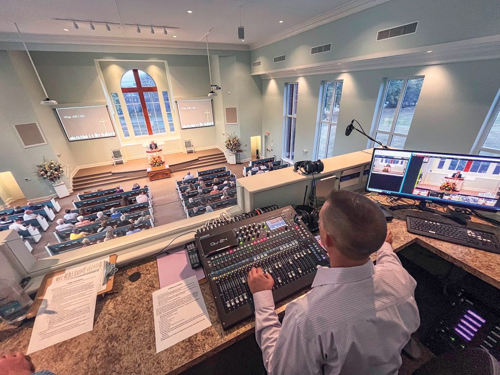 Justin Anderson checks audio levels during the Heritage Church of Christ's 20th anniversary service.