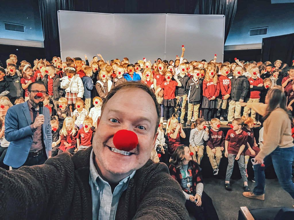 Brad Montague takes a selfie with an auditorium of his red-nosed friends at Oklahoma Christian Academy.