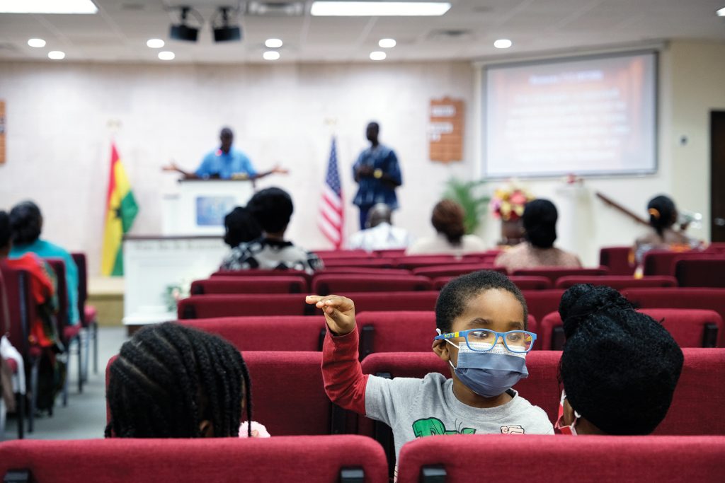 A child plays in the back pews of the North Bronx church during a Bible study.