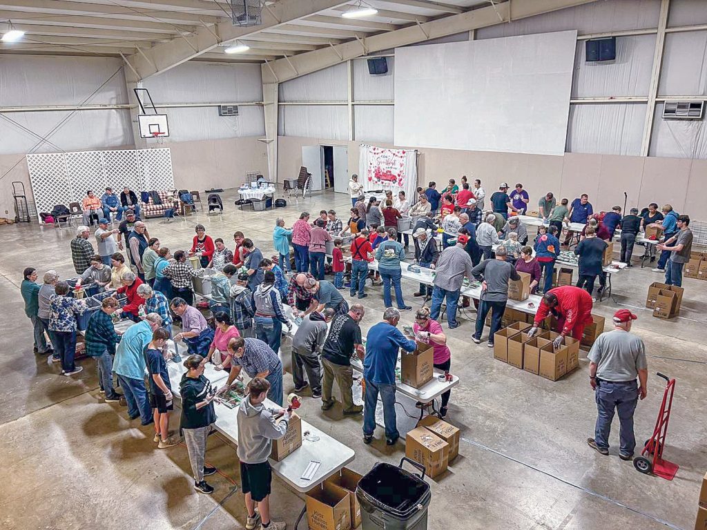 Members of three Churches of Christ and a campus ministry pack meals for Misión Para Cristo.