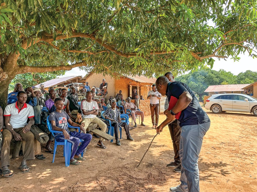 Charles Nii Odoi, a Church of Christ minister and a trainer with Gospel Chariot Missions, draws circles in the dirt to teach Jesus in the village of Nasuwani.