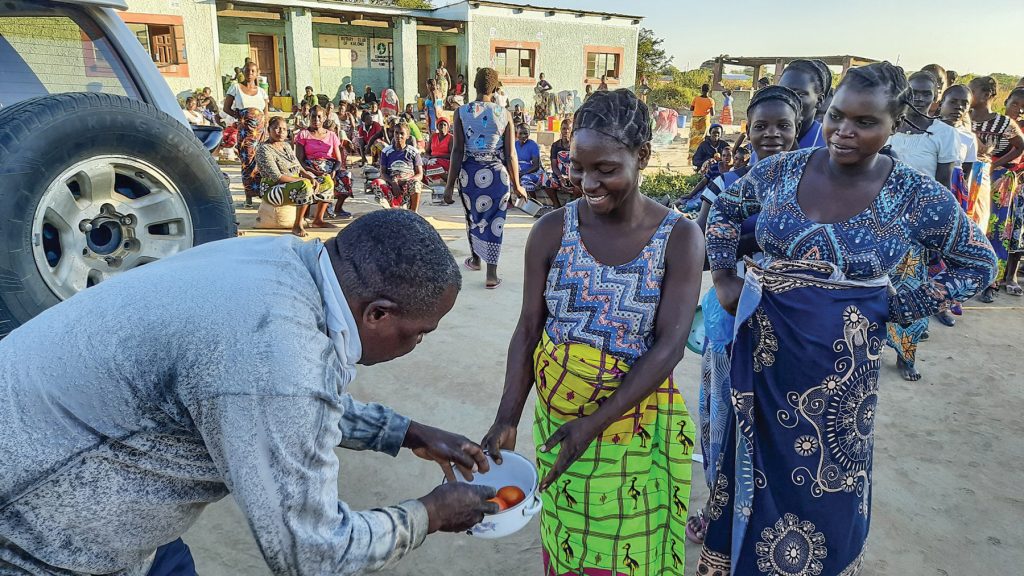 Expectant mothers line up to receive fruits and vegetables from Rodgers Namuswa at the Kalomo Hospital Mother’s Shelter in Zambia.