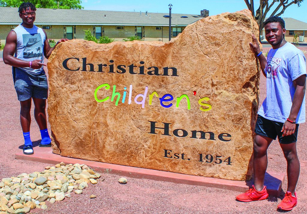 Philip Blidi and Wromiah “Romeo” Gbassagee, both the children of Liberian immigrants, pose by the children’s home’s sign.