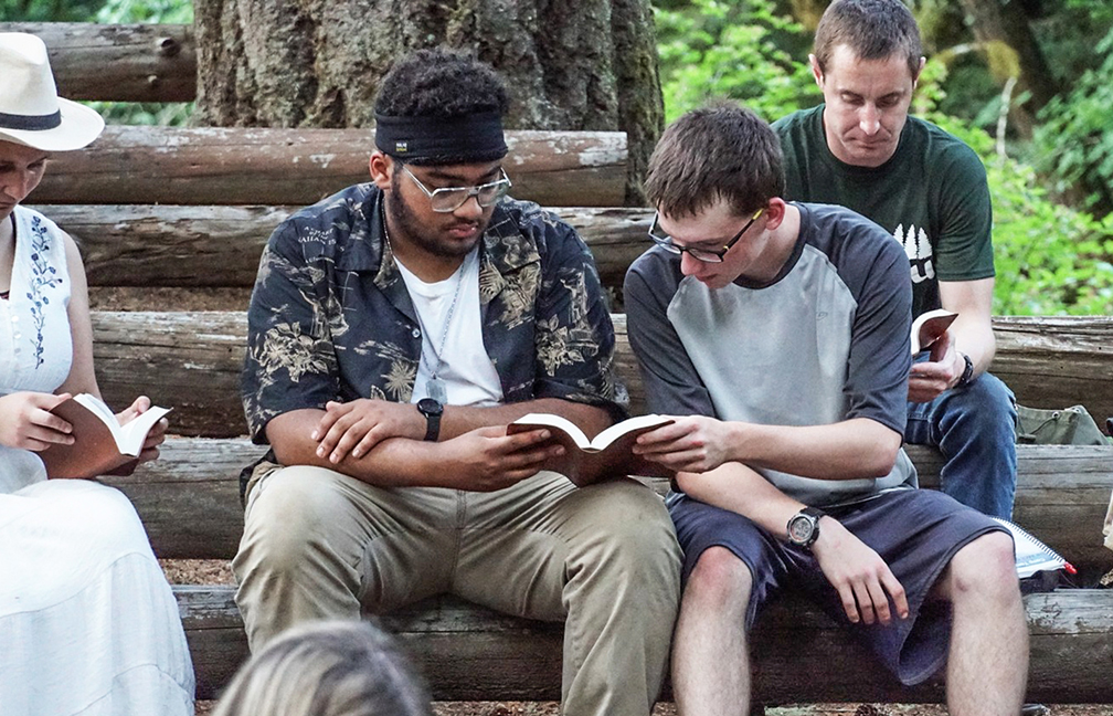 Two campers share a Bible as they follow along with a daily lesson.