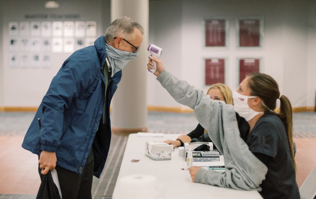 At Oklahoma Christian University, Jeff McCormack, dean of the College of Natural and Health Sciences, gets a temperature check before starting work.