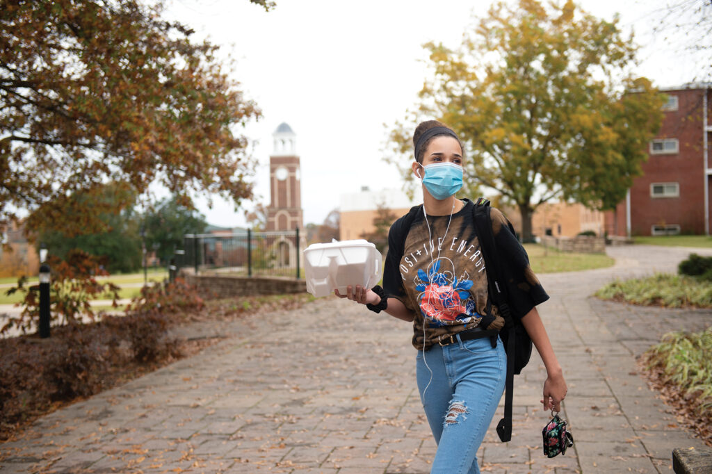 To-go lunch in hand, Brooke Mefford walks alone on the campus of Freed-Hardeman University in Henderson, Tenn.