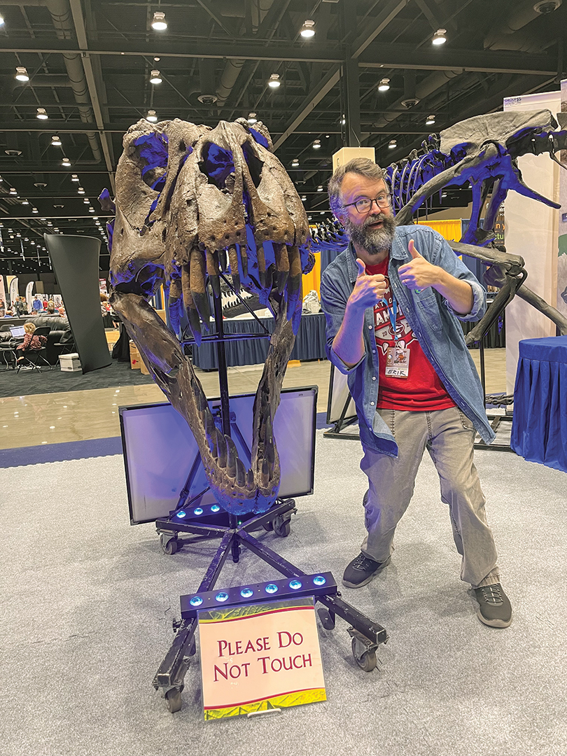 Erik Tryggestad, right, poses with a Tyrannosaurus skull at an exhibit for the Creation Truth Foundation, a group based in Oklahoma that travels to schools and Vacation Bible Schools to talk about evolution and biblical history.