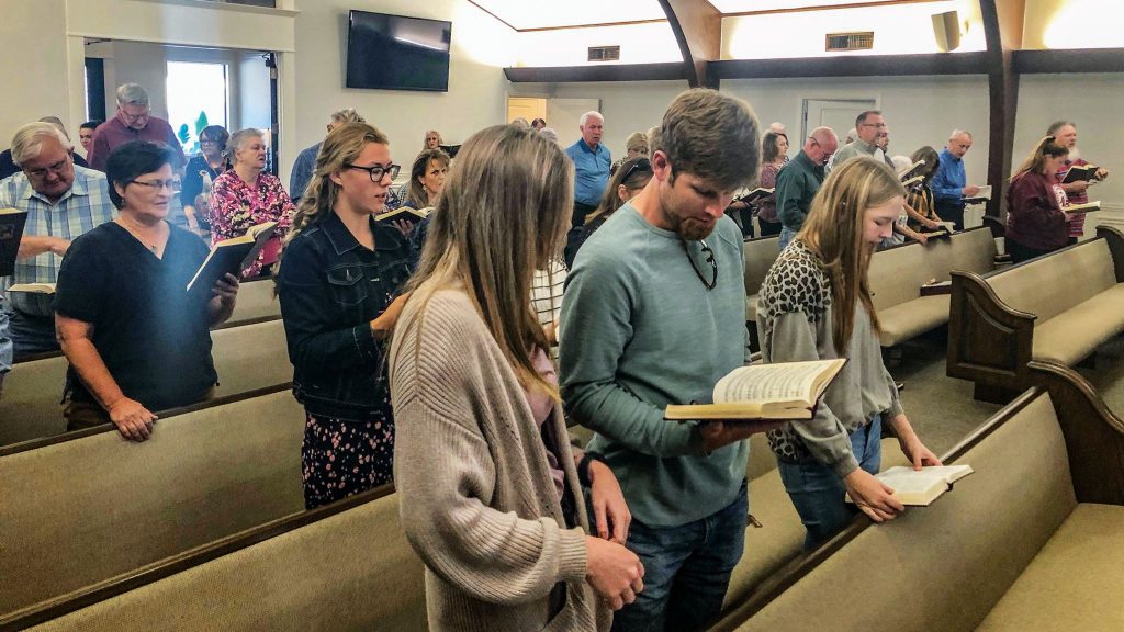 Church members sing from hymnals during Sunday worship in Kerens, Texas.