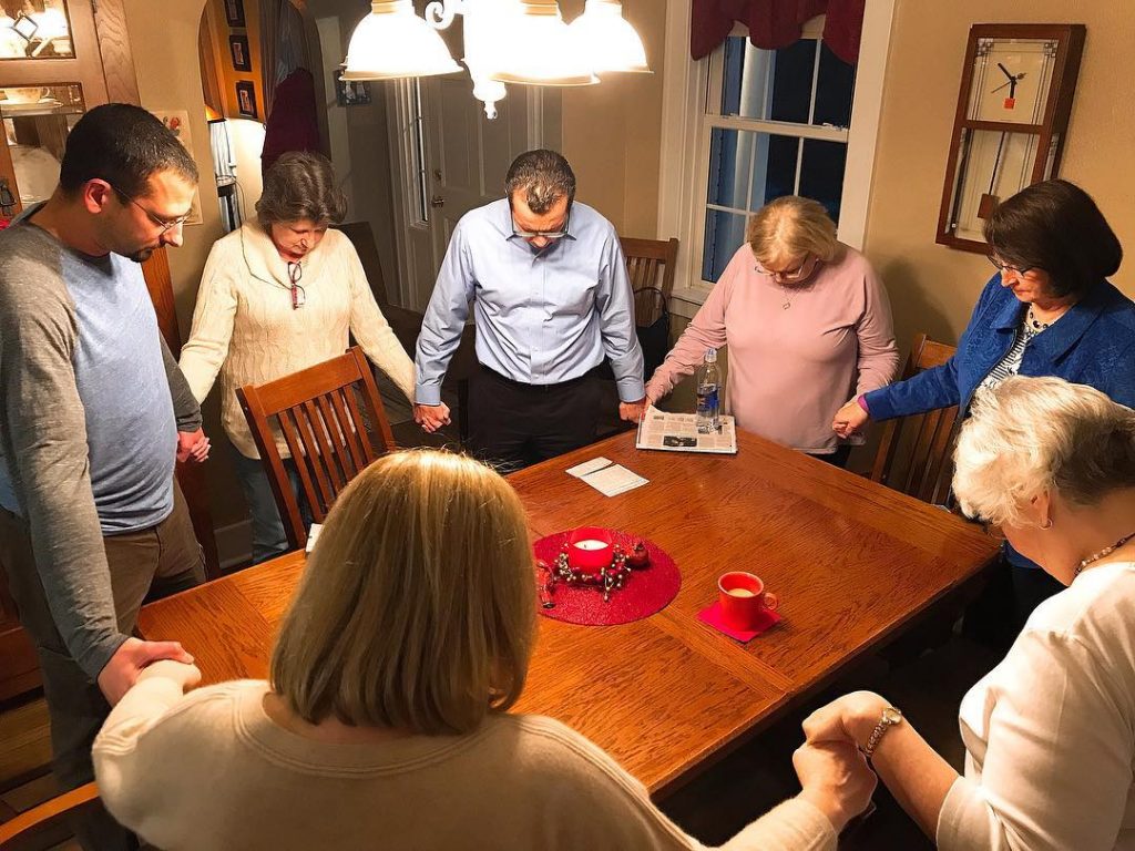 Victims advocate Jimmy Hinton, left, prays with relatives and supporters of Clyde E. Brothers Jr.'s victims.