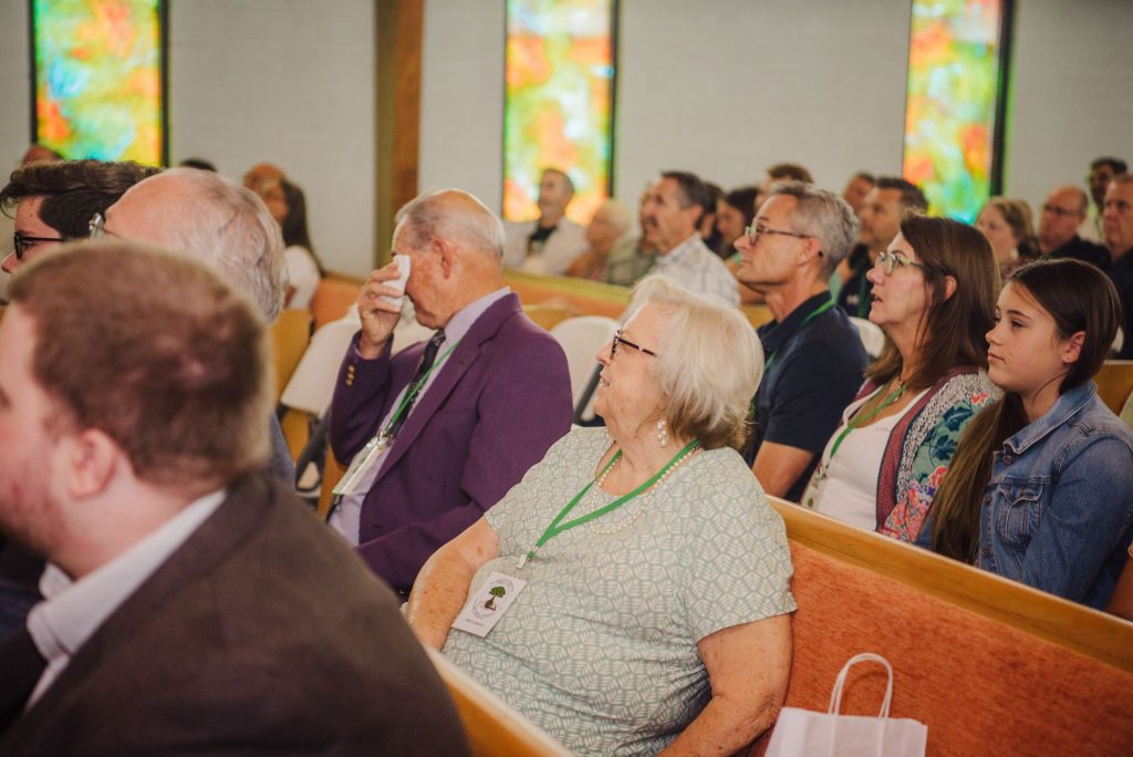 Ron Edwards, seated by his wife, Anne, wipes a tear during a tribute recognizing him on his retirement from full-time preaching.