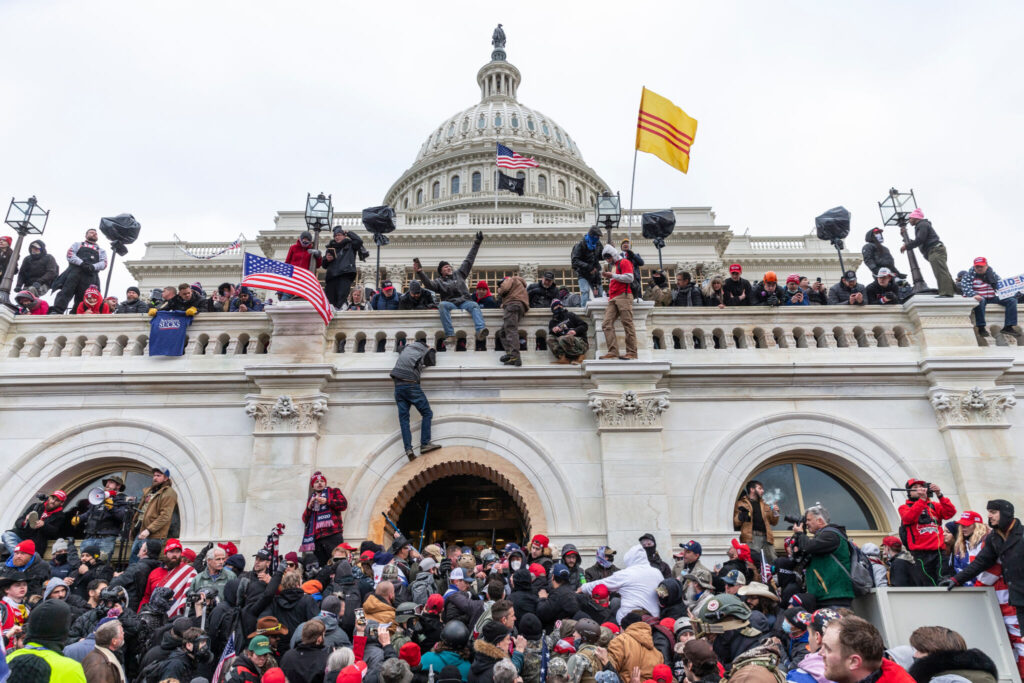 Protesters wave flags and climb the walls of the U.S. Capitol building on Jan. 6.