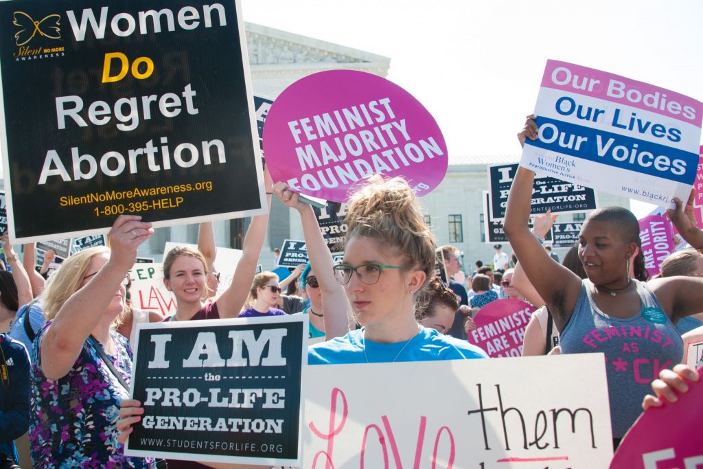 Women on both sides of the abortion debate hold signs in Washington, D.C., in 2016.