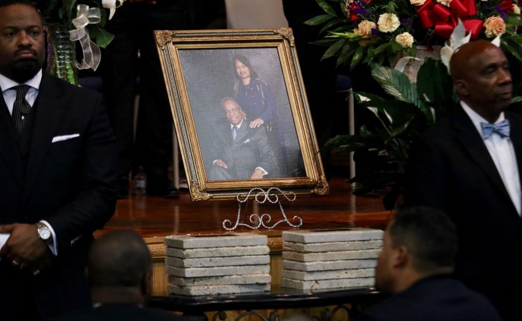 A portrait of Jack Evans Sr. and his wife, Patricia Officer Evans, is shown above 12 memorial stones at the funeral.