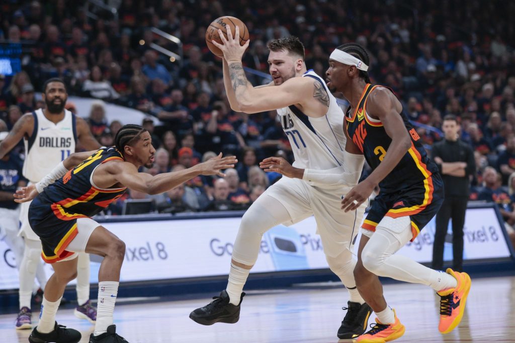 Dallas Mavericks guard Luka Doncic (77) drives against Oklahoma City Thunder guard Aaron Wiggins, left, and guard Shai Gilgeous-Alexander during the first half of Game 5 of an NBA basketball second-round playoff series Wednesday in Oklahoma City.