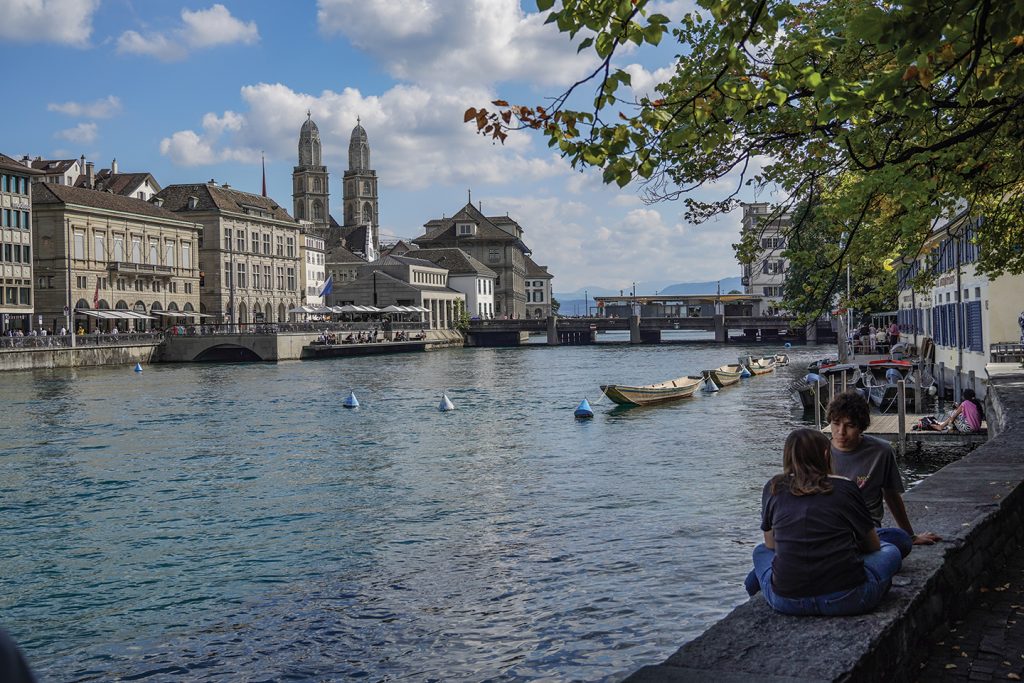 Zurich residents enjoy a warm Sunday afternoon along the banks of the Limmat River near a memorial for Anabaptists who were drowned for their beliefs.