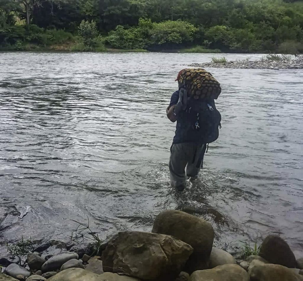 Omar Gil crosses a river to reach a remote village in the mountains of Panama.